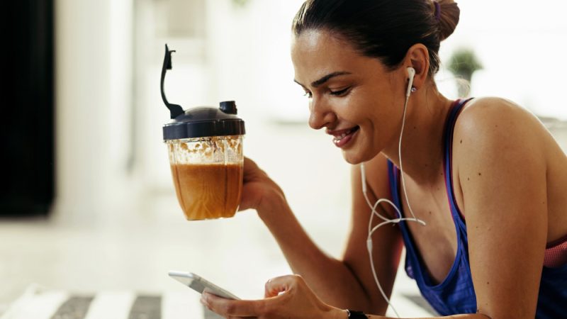 Donna Spotiva che beve uno shake proteico